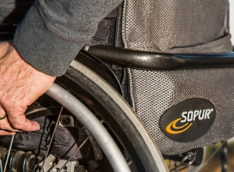 Hand on wheelchair wheel