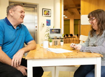 Two people chat in The Brain Charity café