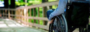 A person in a wheelchair going down a boardwalk