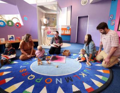 Young children sitting in a circle with parents at a Big Art session