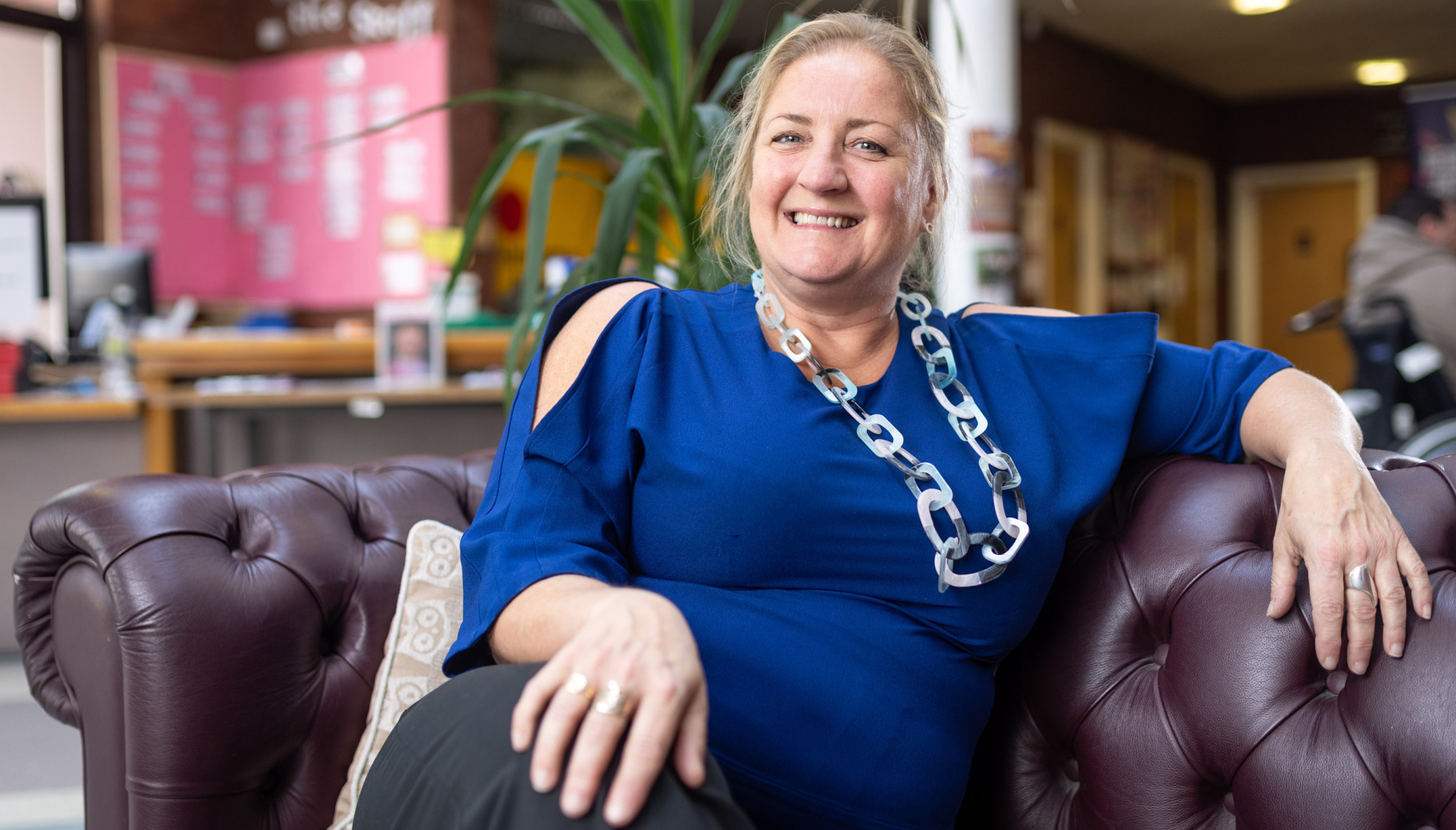 Pippa Sargent sitting on one of the sofas at The Brain Charity