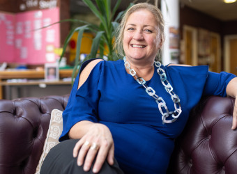 Pippa Sargent sitting on one of the sofas at The Brain Charity