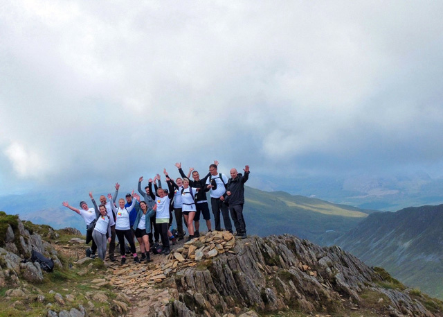 A group of people from Malmaison and Hotel du Vin celebrating at the summit of Snowdon