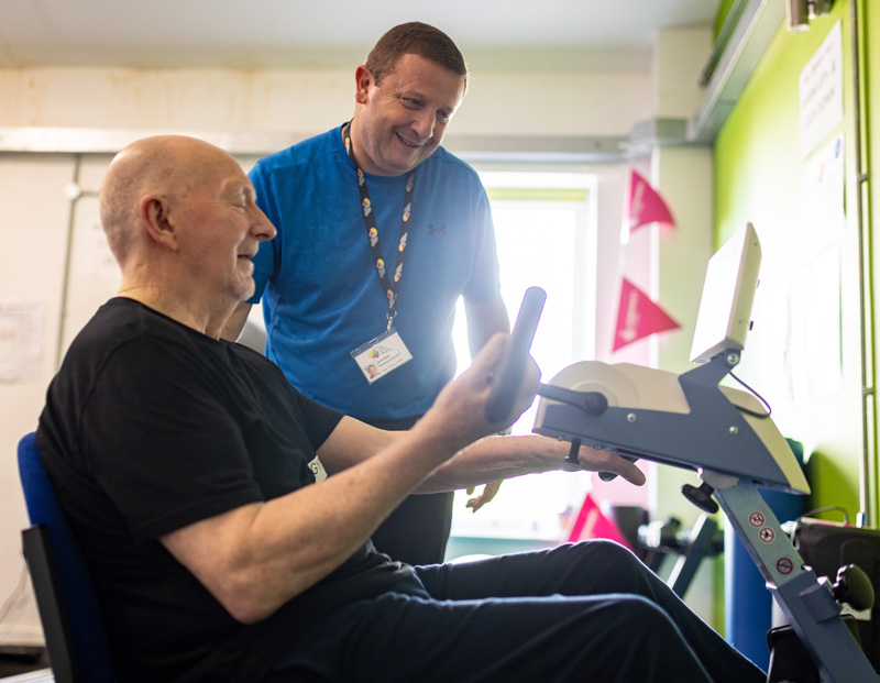 Personal trainer with a man on a gym exercise machine