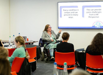 A woman in a wheelchair teaches a class