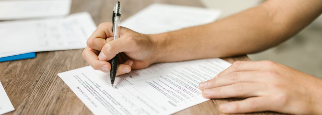 Close up of a person's hands filling in a form