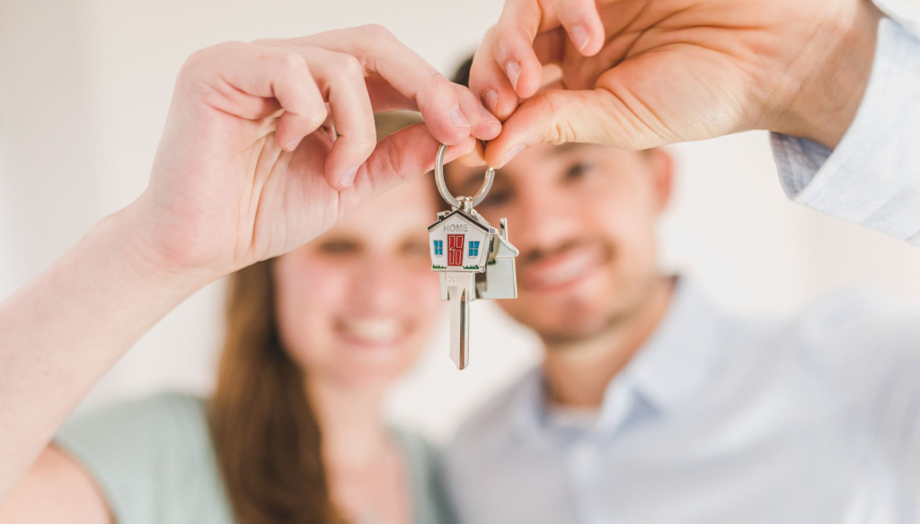 A young couple holding house keys