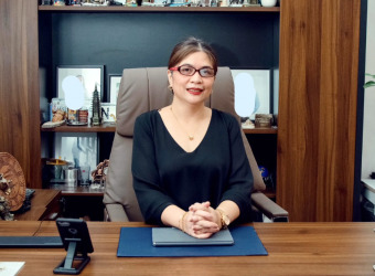 Beverly sitting at a desk in her office