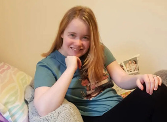 Lydia posing on a bed. Picture used for her article about dyspraxia.