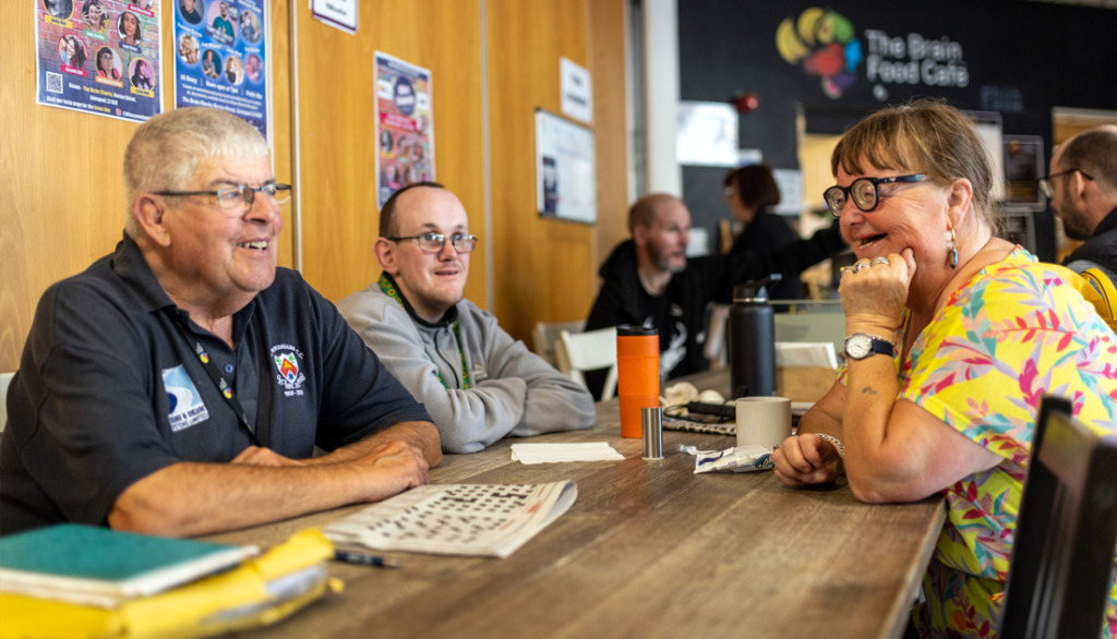 People sitting in The Brain Charity cafe during a break