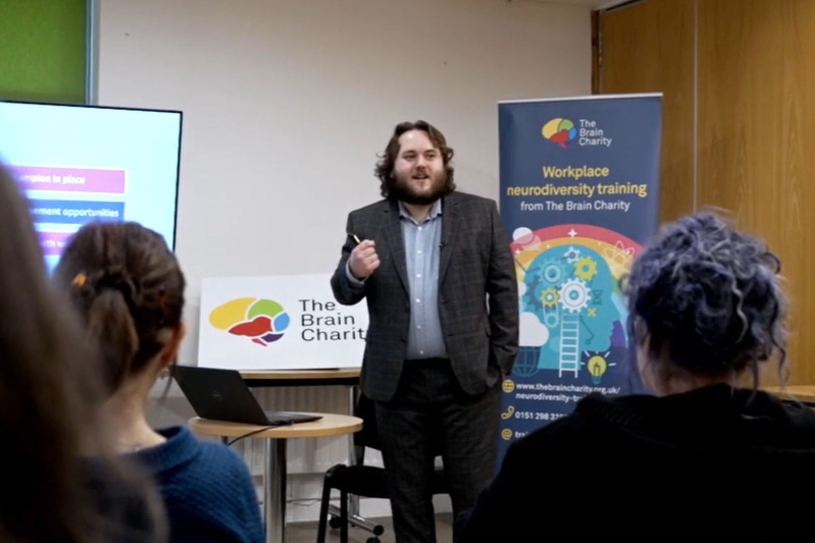 A young man in a suit speaking to an audience of trainees on one of our workplace neurodiversity training courses