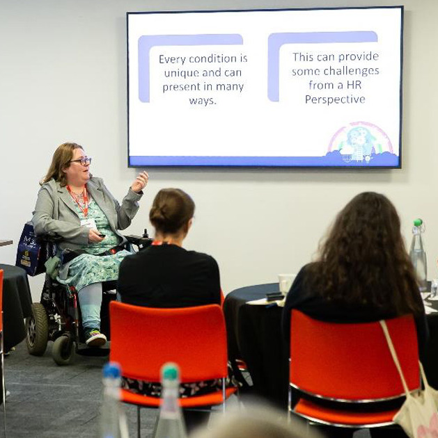 A woman in a wheelchair teaches a class around understanding neurodivergence