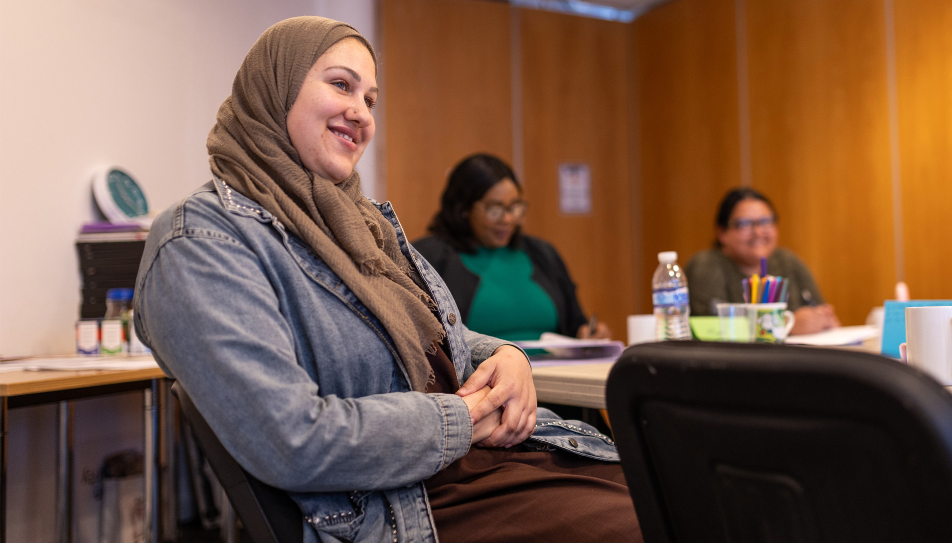 Three women sitting at a table during a training session at The Brain Charity.