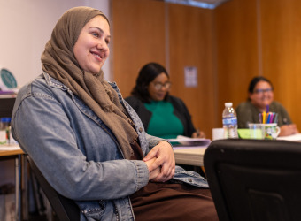 Three women sitting at a table during a training session at The Brain Charity.